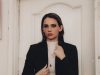 Year-Round Style Staples: Essential Pieces for a Timeless Wardrobe woman in black blazer and white shirt standing beside white wooden door