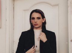 Year-Round Style Staples: Essential Pieces for a Timeless Wardrobe woman in black blazer and white shirt standing beside white wooden door