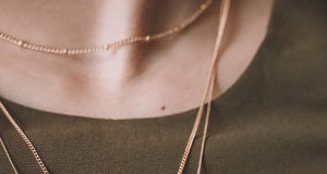 More Than Just the Finishing Touch: How Accessories Shape Identity and Style person wearing silver necklace with silver pendant