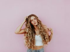 Forever in Style: The Enduring Allure of Timeless Jewelry Pieces woman standing next to pink wall while scratching her head