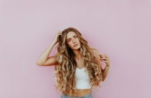 Forever in Style: The Enduring Allure of Timeless Jewelry Pieces woman standing next to pink wall while scratching her head