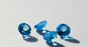 Layered Luxury: The Art of Ring Stacking and Personal Expression blue stone on white surface