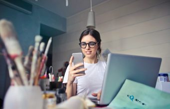 Smart Style, Big Impact: Fashion Hacks That Empower Petite Figures woman in white shirt using smartphone