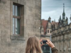 Pack Light, Travel Far: Real-World Tricks for Smarter Travel in 2025 woman in gray jacket taking photo using black dslr camera