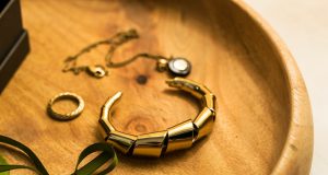 Timeless Statements: How Watches Became Fashion’s Most Personal Power Piece gold and green bracelet on brown textile