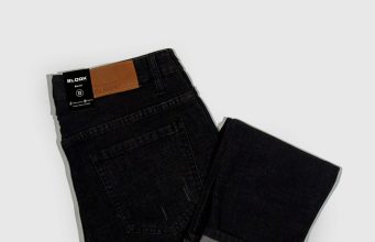 Cuffed or Cropped? The Subtle Art of Rolling vs. Hemming Your Pants a pair of black jeans on a white background